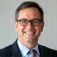 Headshot of Carlos Rodriguez, a man with short hair and glasses, smiling confidently.